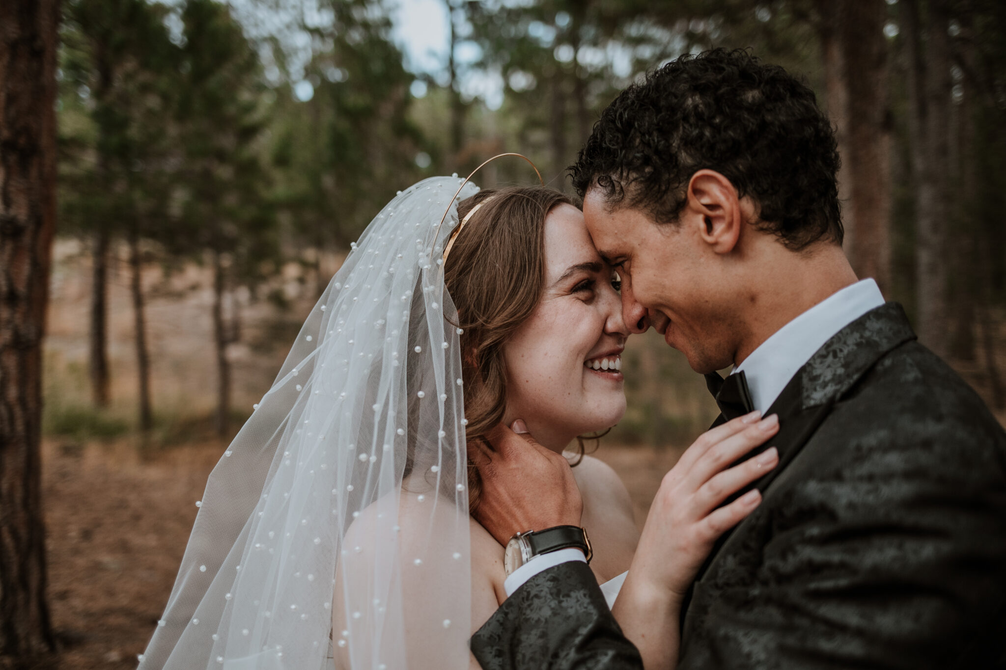 Romantic close-up of bride and groom forehead to forehead in the forest at Wedgewood Weddings Colorado Springs