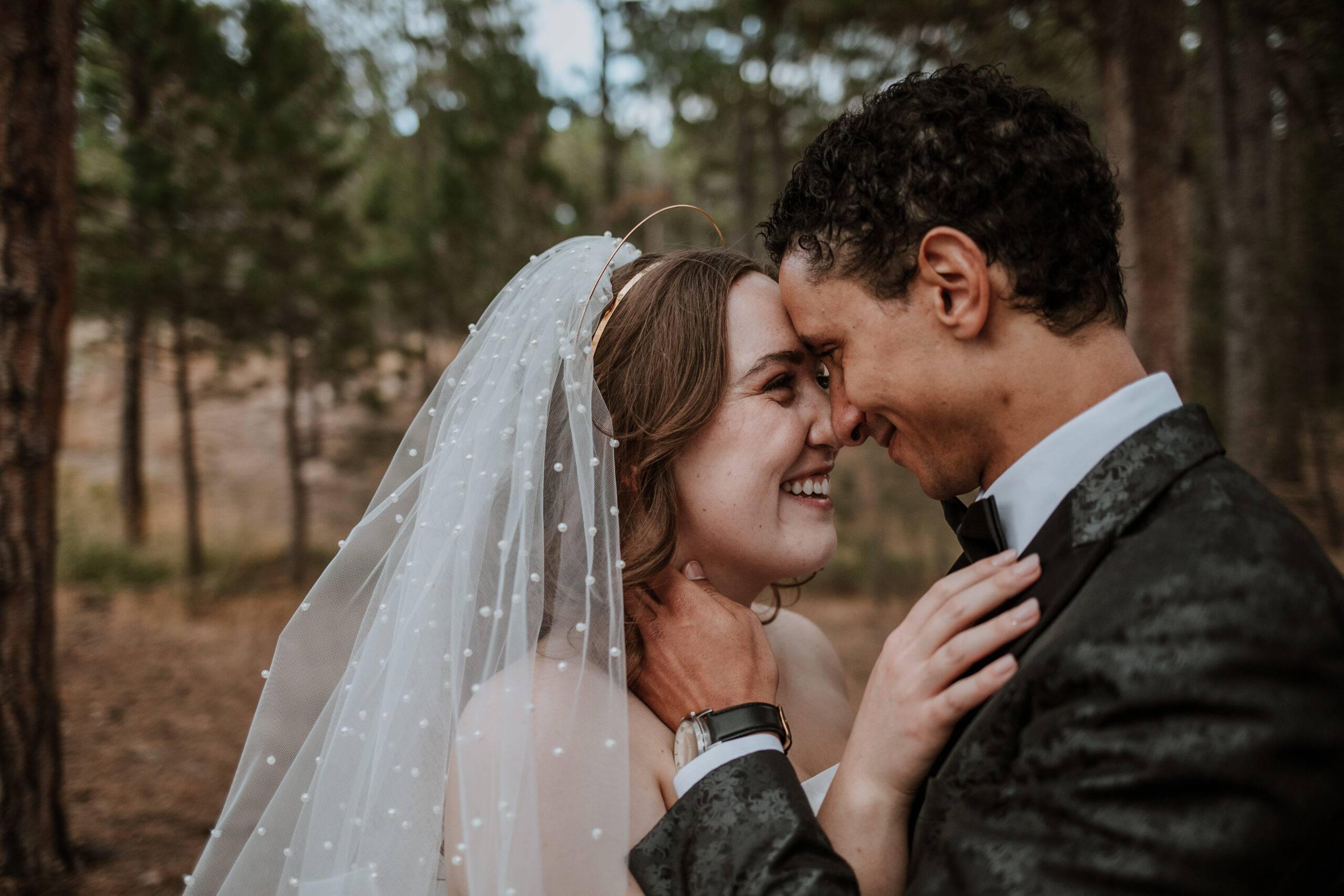 Romantic close-up of bride and groom forehead to forehead in the forest at Wedgewood Weddings Colorado Springs